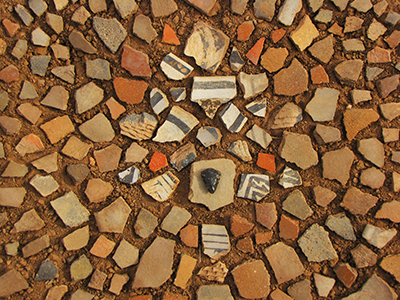 Pottery shards, pottery shards and more pottery shards; with an obsidian arrowhead in the middle.